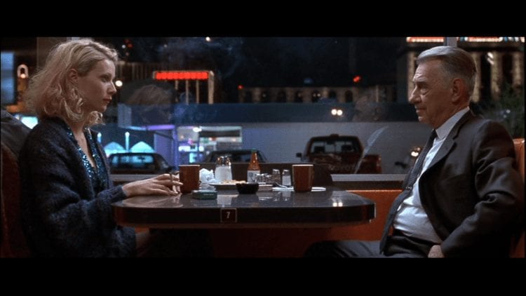 Phillip Baker Hall and Gwyneth Paltrow sit opposite each other in a diner at night in Hard Eight