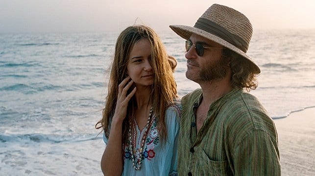 Joaquin Phoenix walks along the beach with his girlfriend 