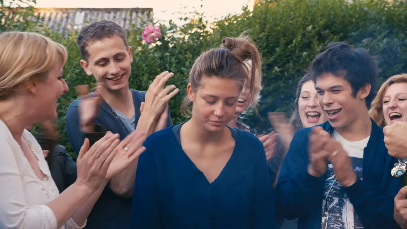 Adèle Exarchopoulos as Adèle being clapped by a crowd of people laughing in Blue Is the Warmest Colour