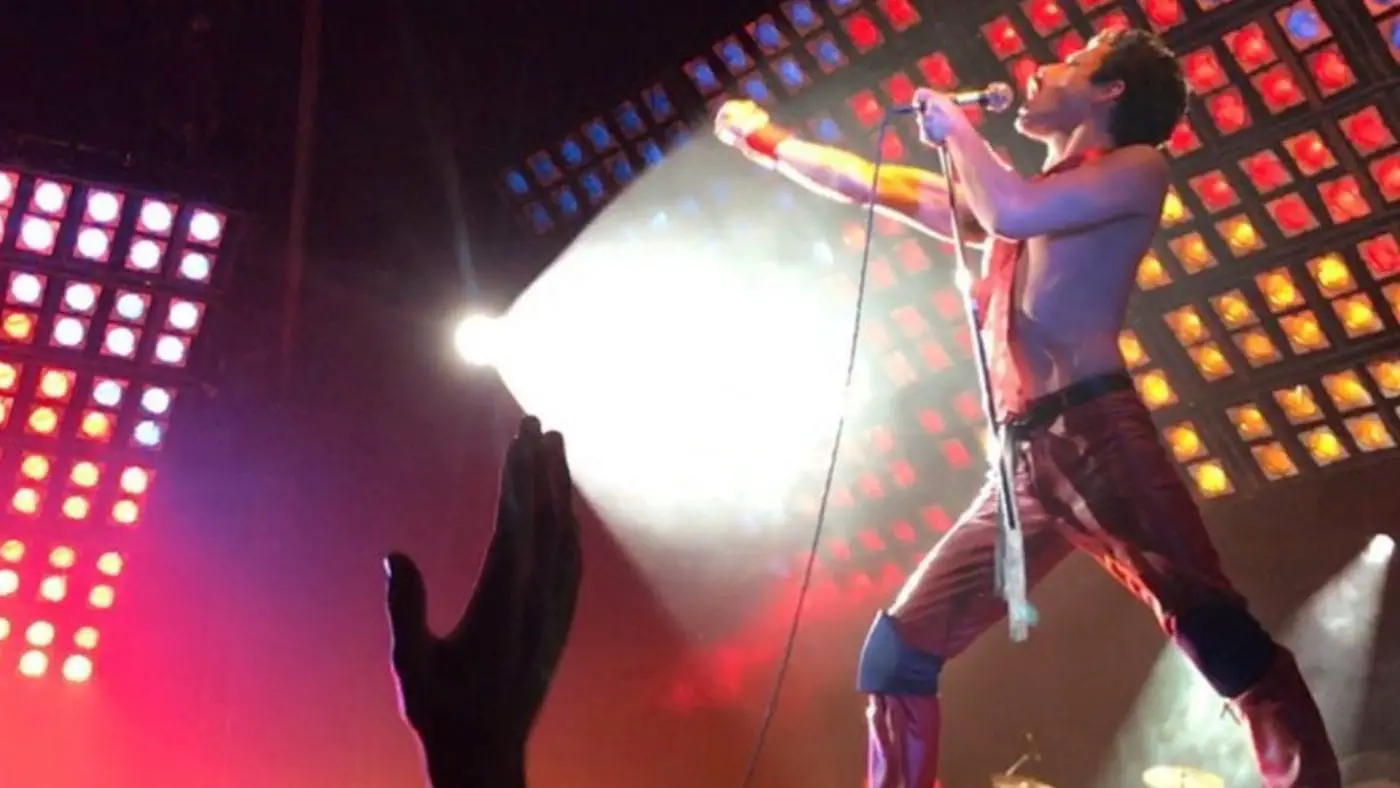 Rami Malek portraying Freddie Mercury in concert