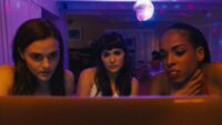 Alice/Lola looks at her doppelganger with other cam girls in Netflix's Cam