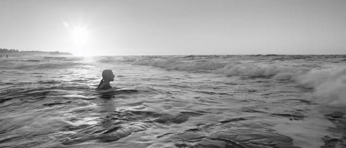 Cleo wades into the ocean in this still from Roma.