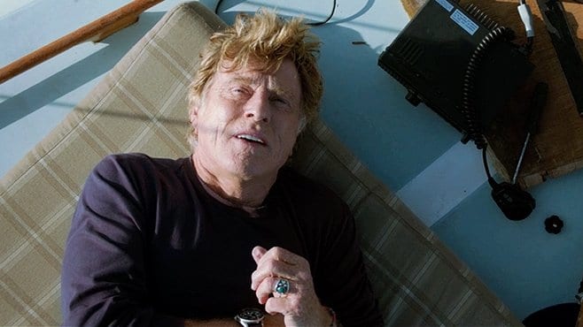 Robert Redford lies on the boat deck looking up at the sky in All is Lost