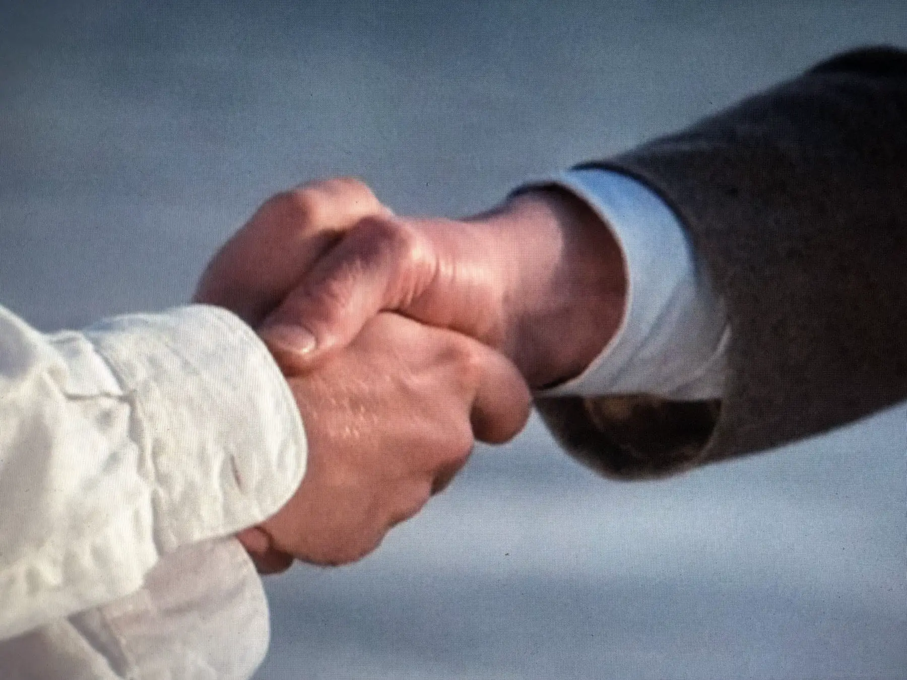 A closeup of Ronnie and Giles shaking hands