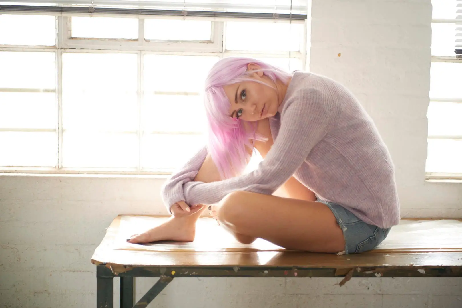 Black Mirror's Ashley O (portrayed by Miley Cyrus) sitting down with a pink wig on