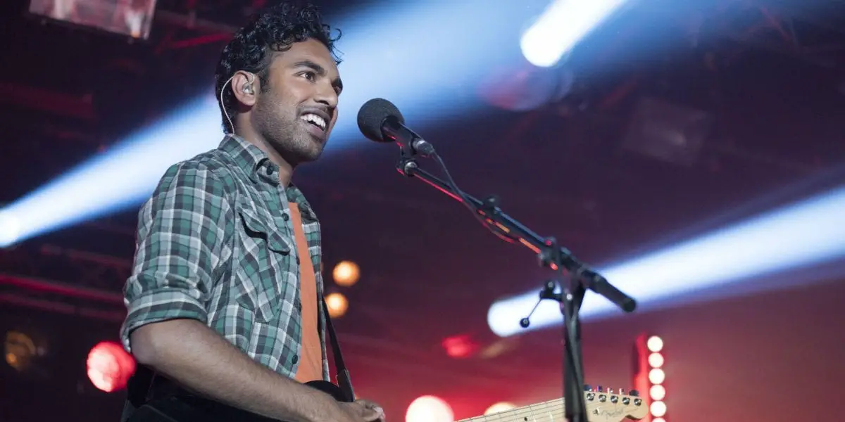 Himesh Patel plays an electric guitar on stage