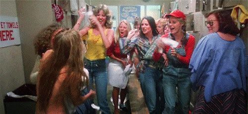 A group of girls in a locker room laugh and throw tampons at nude Carrie White (Sissy Spacek).
