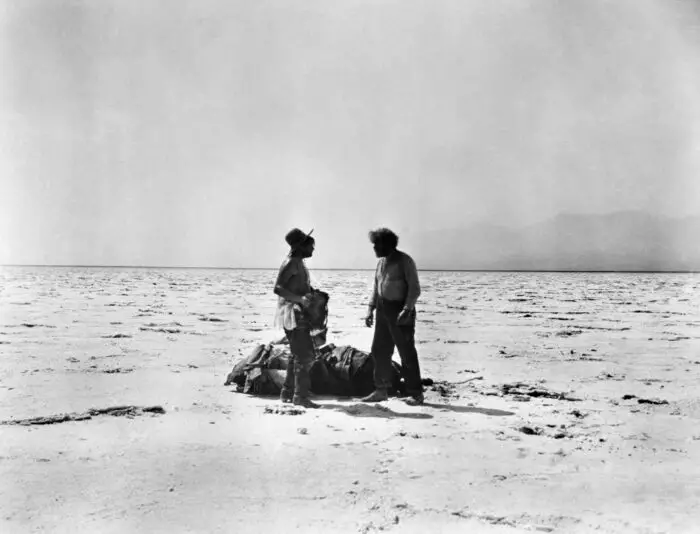 Two figures in the harsh desert landscape of Death Valley