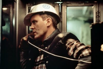 Burk (John Lithgow) wearing a hard hat and talking on a telephone in Blow Out