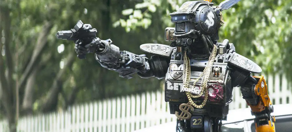 Chappie holds his gun like a gangster as he threatens the bad guys he believes stole his fathers car