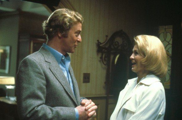 Kate, in a white suite and British man (Michael Caine) in grey suit are in a therapist office