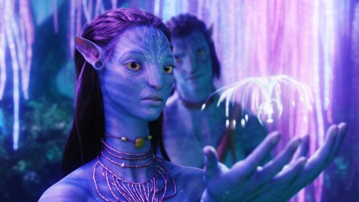 Neytiri looking at a glowing thing in her hands