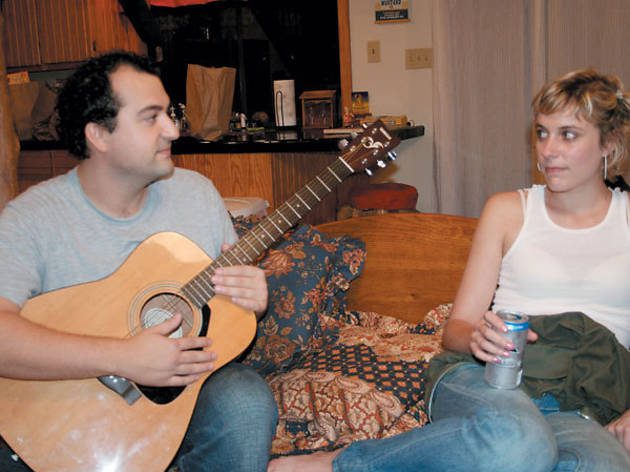 Sitting on the sofa, Chad plays the guitar while Michelle listens