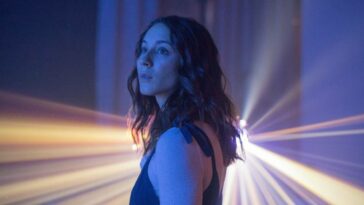 Clara (Bellisario) observes a projected starfield with wonderment.