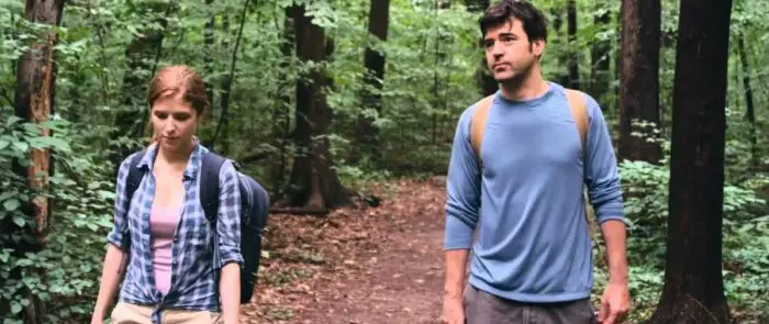 Jill (Anna Kendrick) walks with Chris (Ron Livingston) in a wood