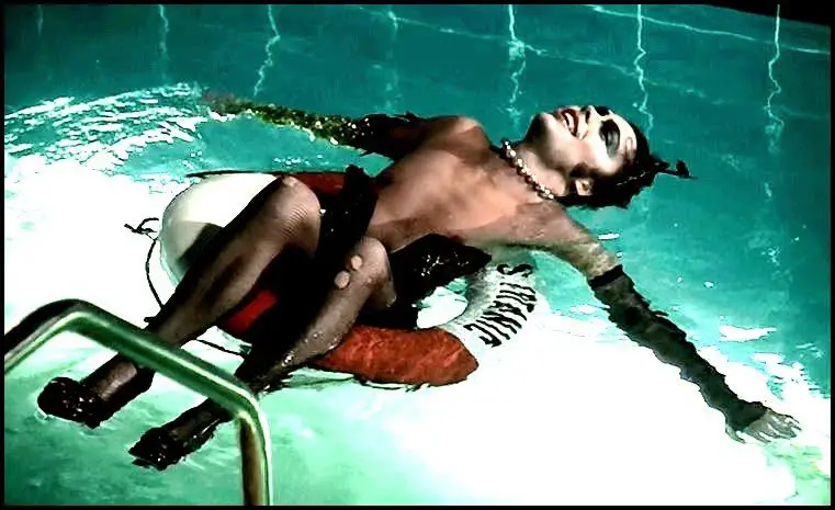 Dr Frank. N Furter laying in a swimming pool