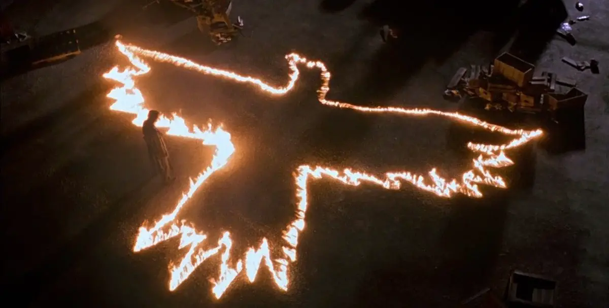 The Crow symbol drawn in fire on a city street