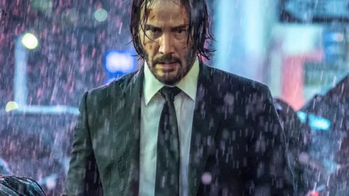 Hunted and alone, John Wick stands on rainy New York streets.