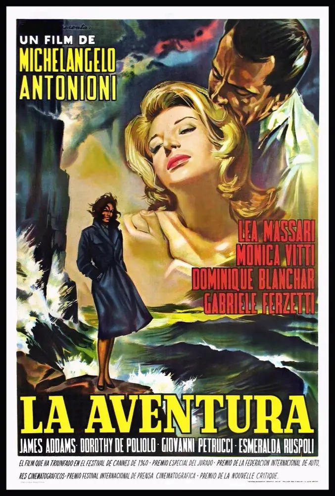 A blonde socialite is embraced by a dark haired man above a mysterious woman in a dark overcoat standing on a rocky bluff