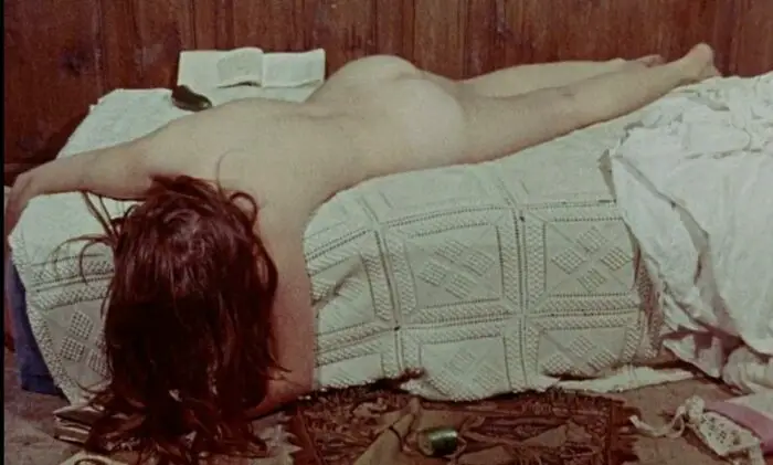 Therese philosophe lying naked facedown on a bed, head lolling off the side