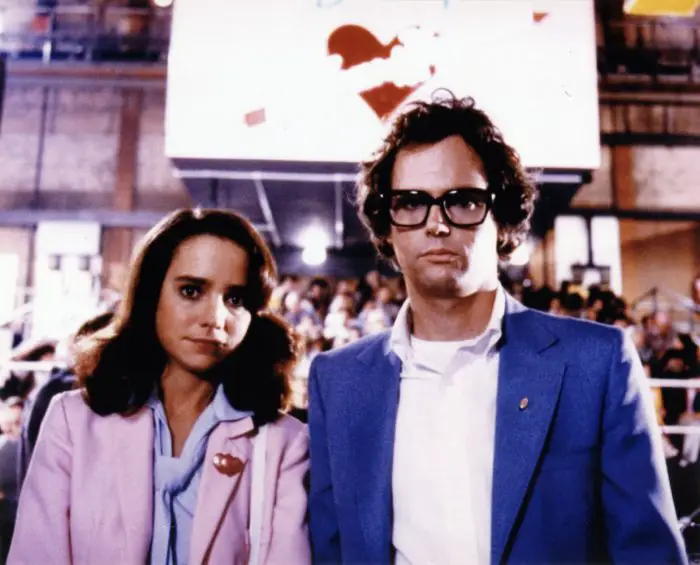 Janet (Jessica Harper) and Brad Majors (Cliff De Young) stand in from of the Denton Home of Happiness sign in "Shock Treatment"