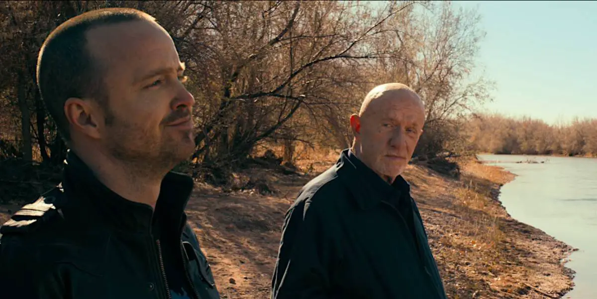 Mike Ehrmantraut looks at Jesse Pinkman as they stand on a riverbed
