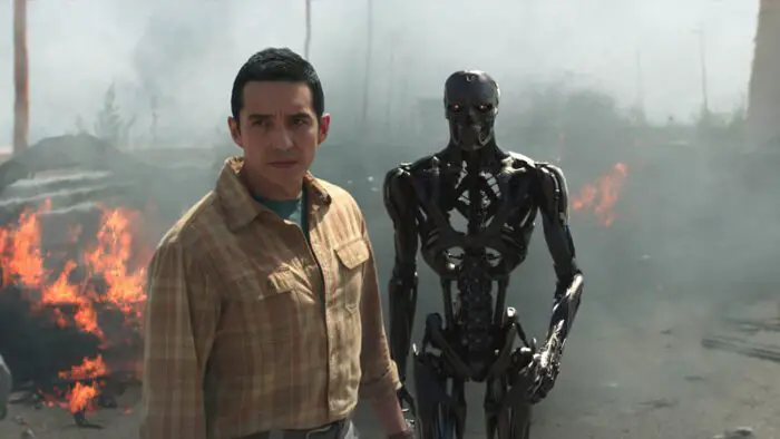 Rev-9 and his robot counterpart look to the distance surrounded by fire