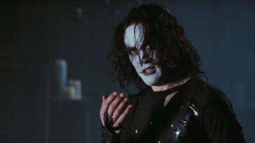 Eric Draven raises his hand and stares at someone out of frame