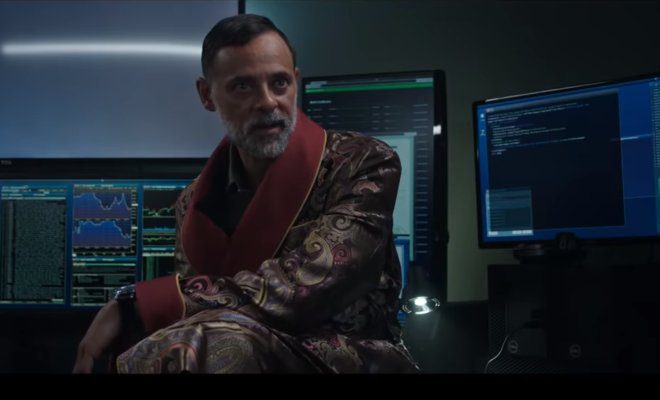 Alexander Siddig sits in front of computers talking