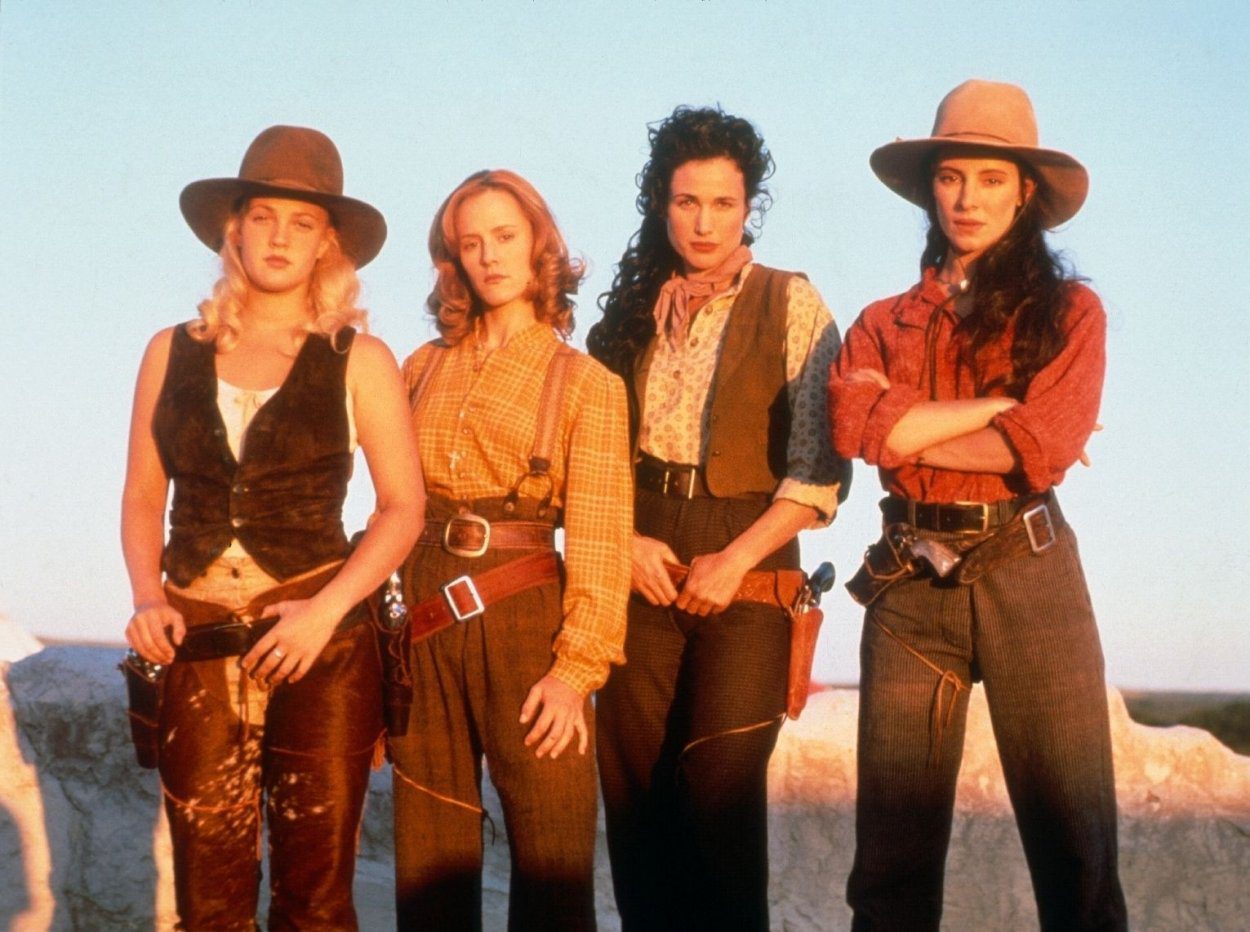 The women of Bad Girls pose in stereotypical Cowboy fashion, with either their hands to their guns or their arms crossed..