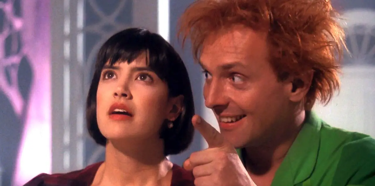A promo image of Drop Dead Fred where Phoebe Cate's side eyes an upside down Rik Mayall.