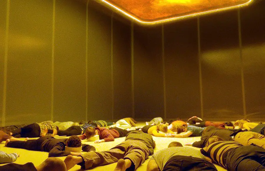 A room of people laying face down on the floor