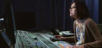 Ai-Ling Lee uses a soundboard to edit sound effects into a film