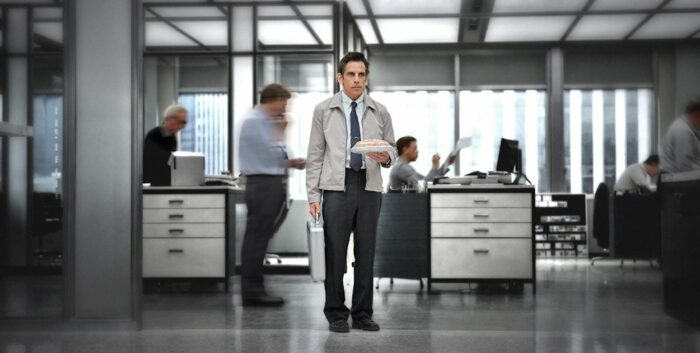 The world blurs by Walter Mitty as he stands in an office and stares off in a daydream in