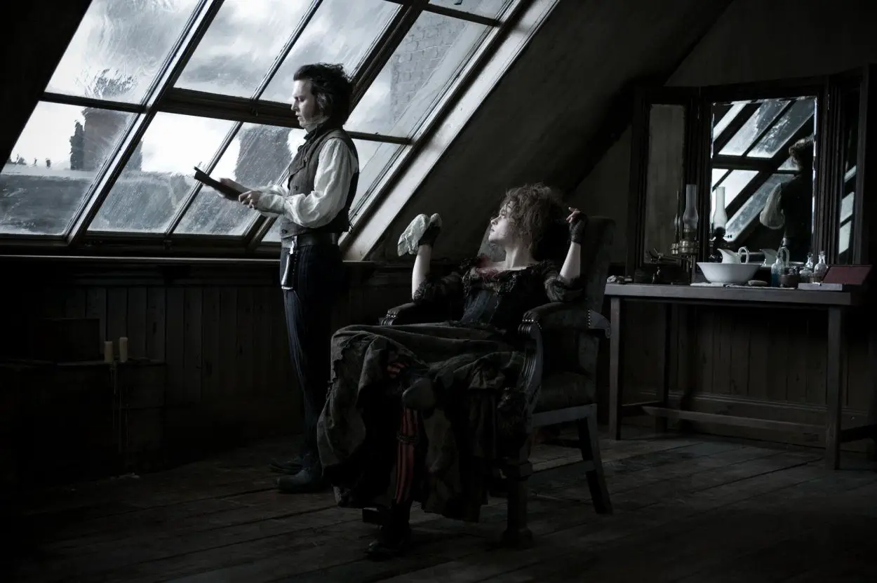 Mrs Lovett lounges in Todd's barber chair, while Todd broods out the window