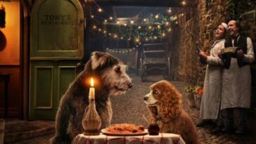 Two dogs dine over spaghetti and wine.