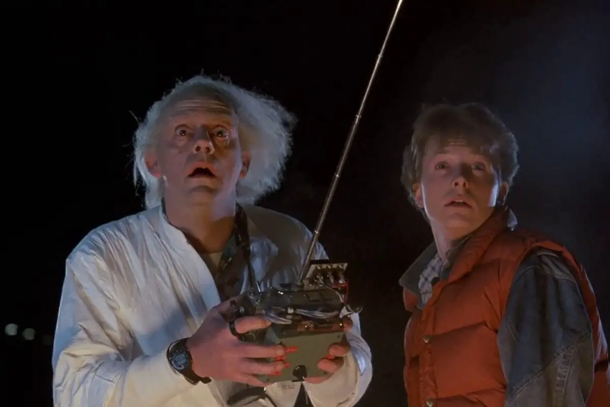 Marty McFly and Doc Brown staring at something in awe; Doc is holding a remote control.
