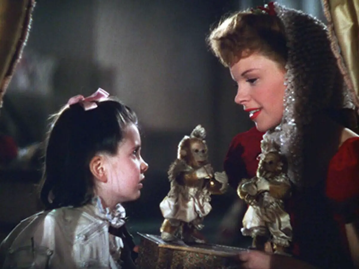 Esther (Judy Garland) sings to Tootie while holding toy monkeys
