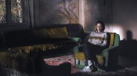 Kristen Stewart sits in an empty room.