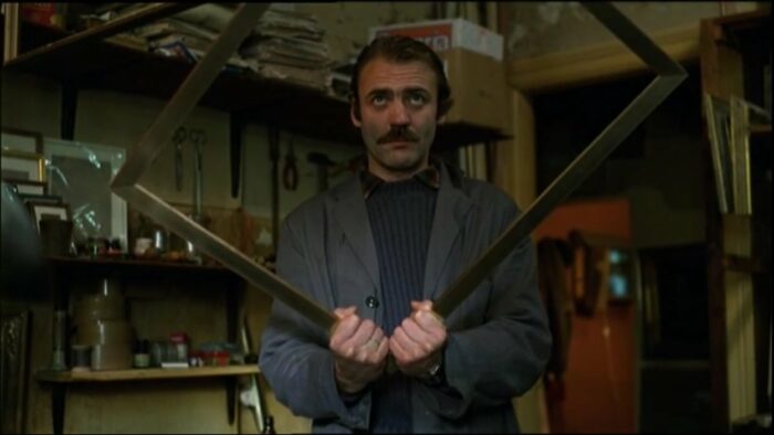 Bruno Ganz as Zimmermann holding a picture frame