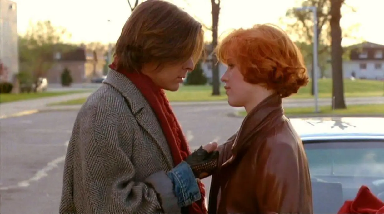 John Bender and Claire Standish face each other in a tender moment together in the school parking lot at the end of their detention day