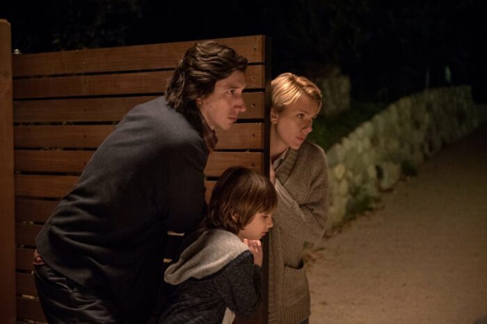 Adam Driver and Scarlett Johansson close a gate with their son at night