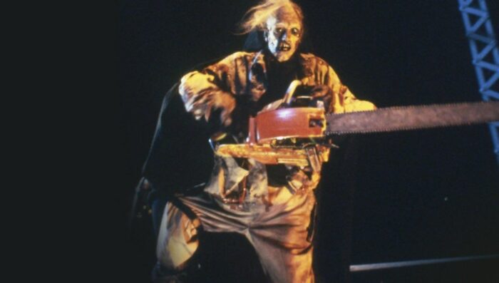 Leatherface wearing the dead body of the hitchhiker and revving his chainsaw