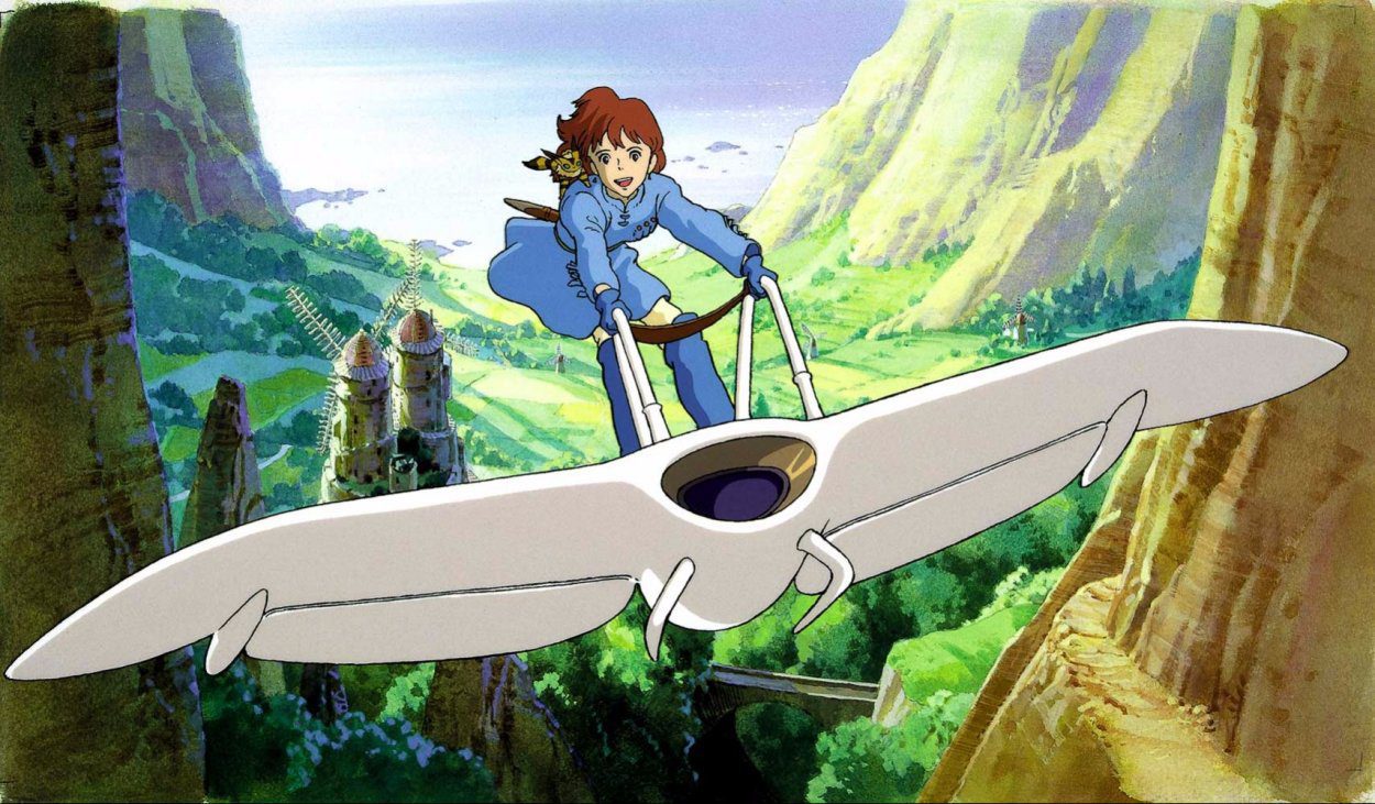 Nausicaä flies through a canyon , standing on her glider