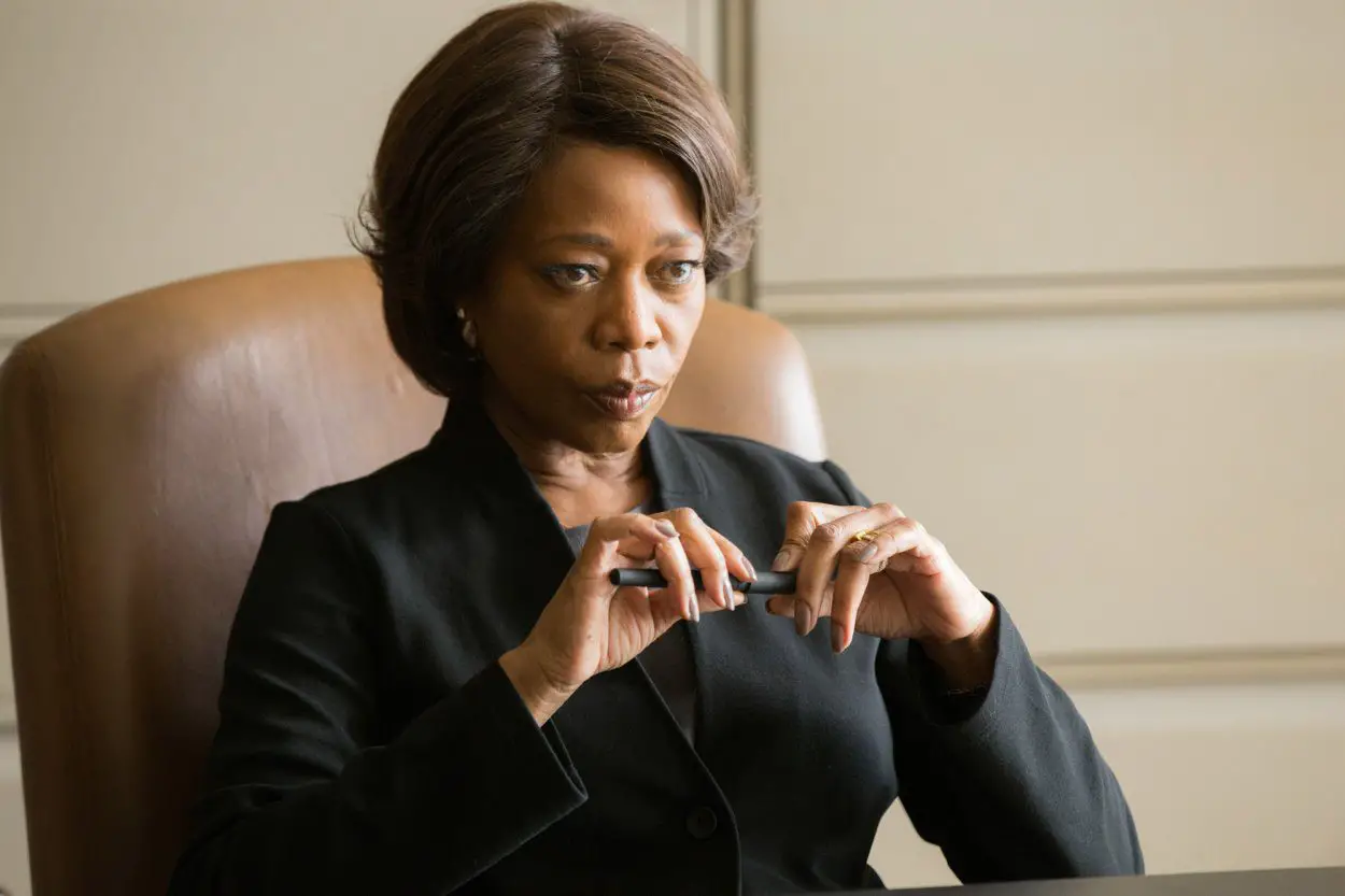Alfre Woodard listens to the pleas of a inmate's family at her desk.