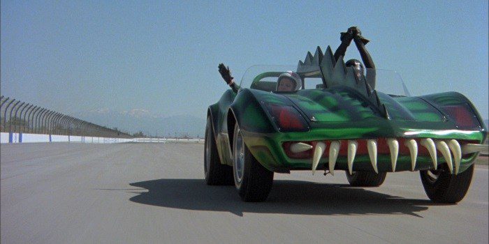 Frankenstein's green death mobile with sharp fins and gnarly teeth on the front bumper