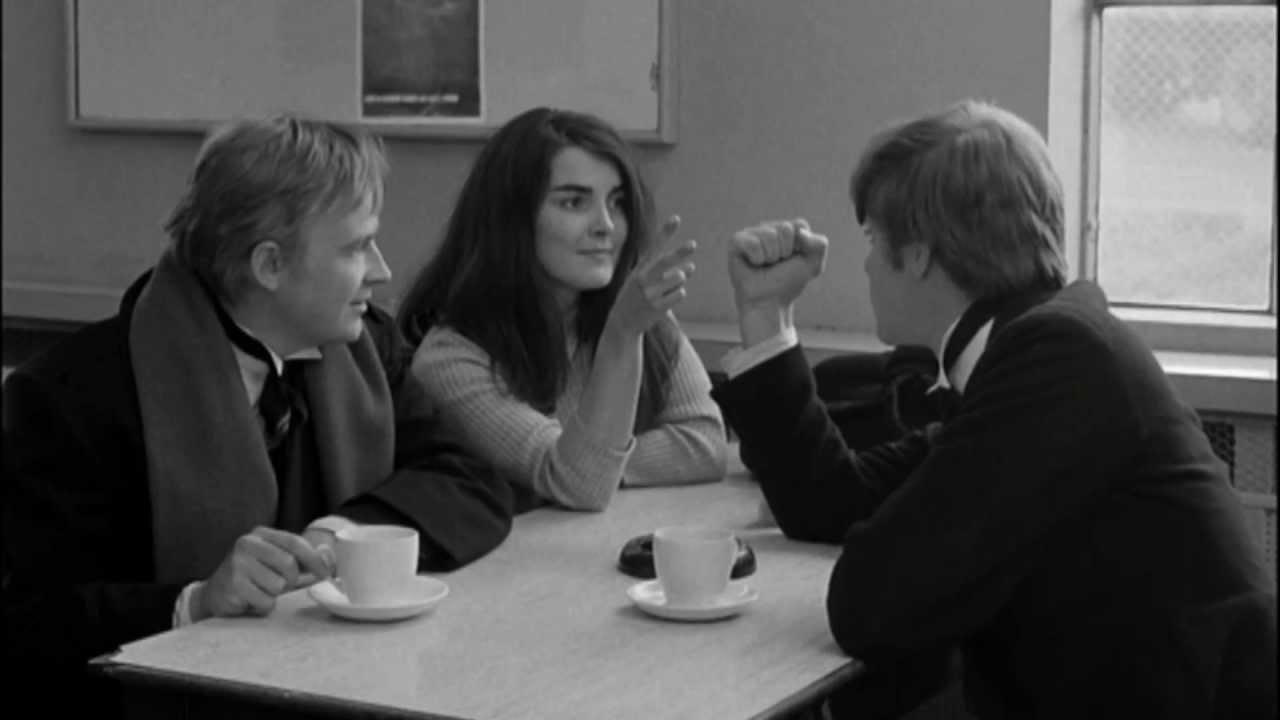Mick, Johnny and The Girl play Rock, Paper, Scissors at a cafe table