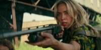 Emily Blunt points a shotgun at an unknown figure