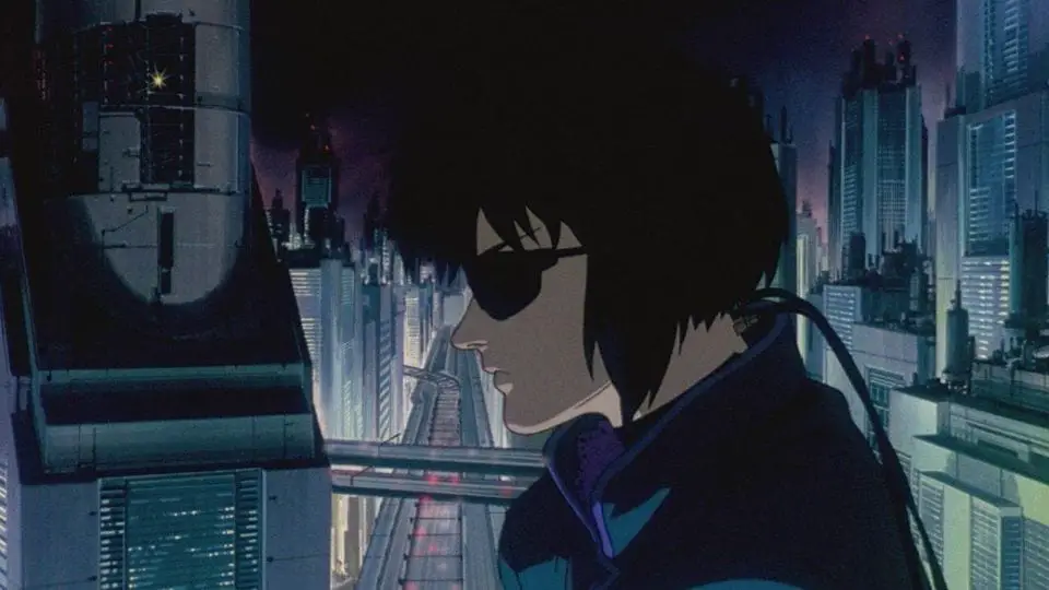 Kusanagi sits, plugged into the network with the city skyline behind her