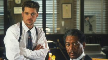 Brad Pitt and Morgan Freeman as detectives sit around a desk in Seven